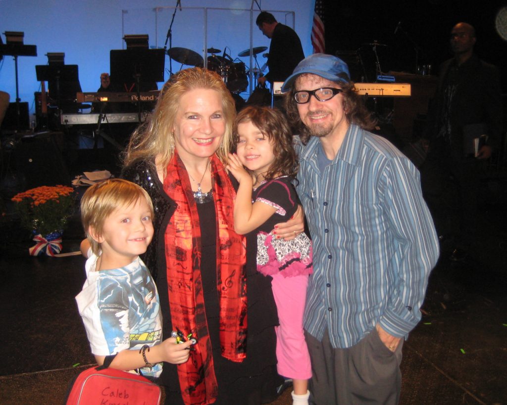 A family posing for the camera in front of a stage.