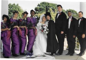 Four people singing outdoors in winter with songbooks.