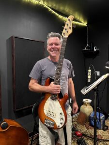 Four people singing outdoors in winter with songbooks.