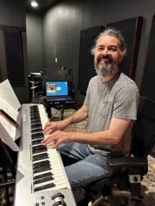 Four people singing outdoors in winter with songbooks.