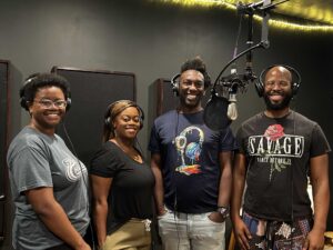 Four people singing outdoors in winter with songbooks.