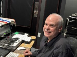 Four people singing outdoors in winter with songbooks.