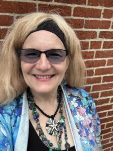 Four people singing outdoors in winter with songbooks.