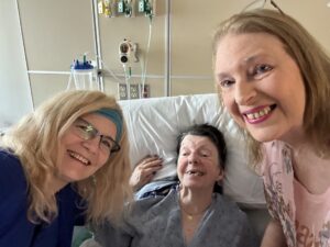 Four people singing outdoors in winter with songbooks.