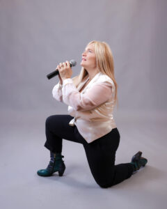 Four people singing outdoors in winter with songbooks.