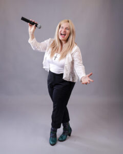 Four people singing outdoors in winter with songbooks.