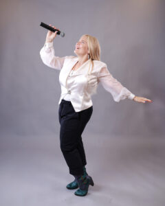 Four people singing outdoors in winter with songbooks.
